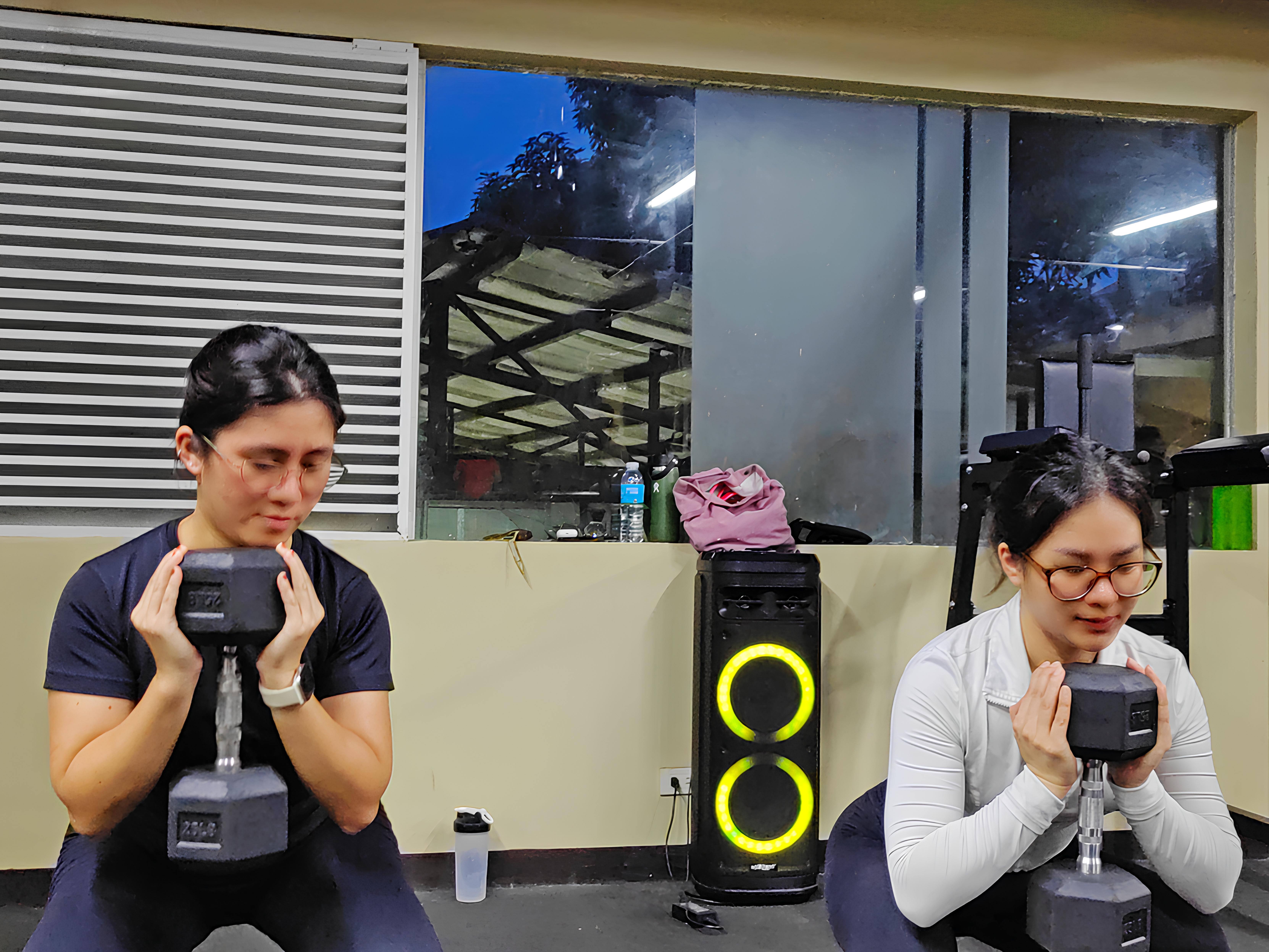 Two members doing squats using dumbbell which is a strength training example