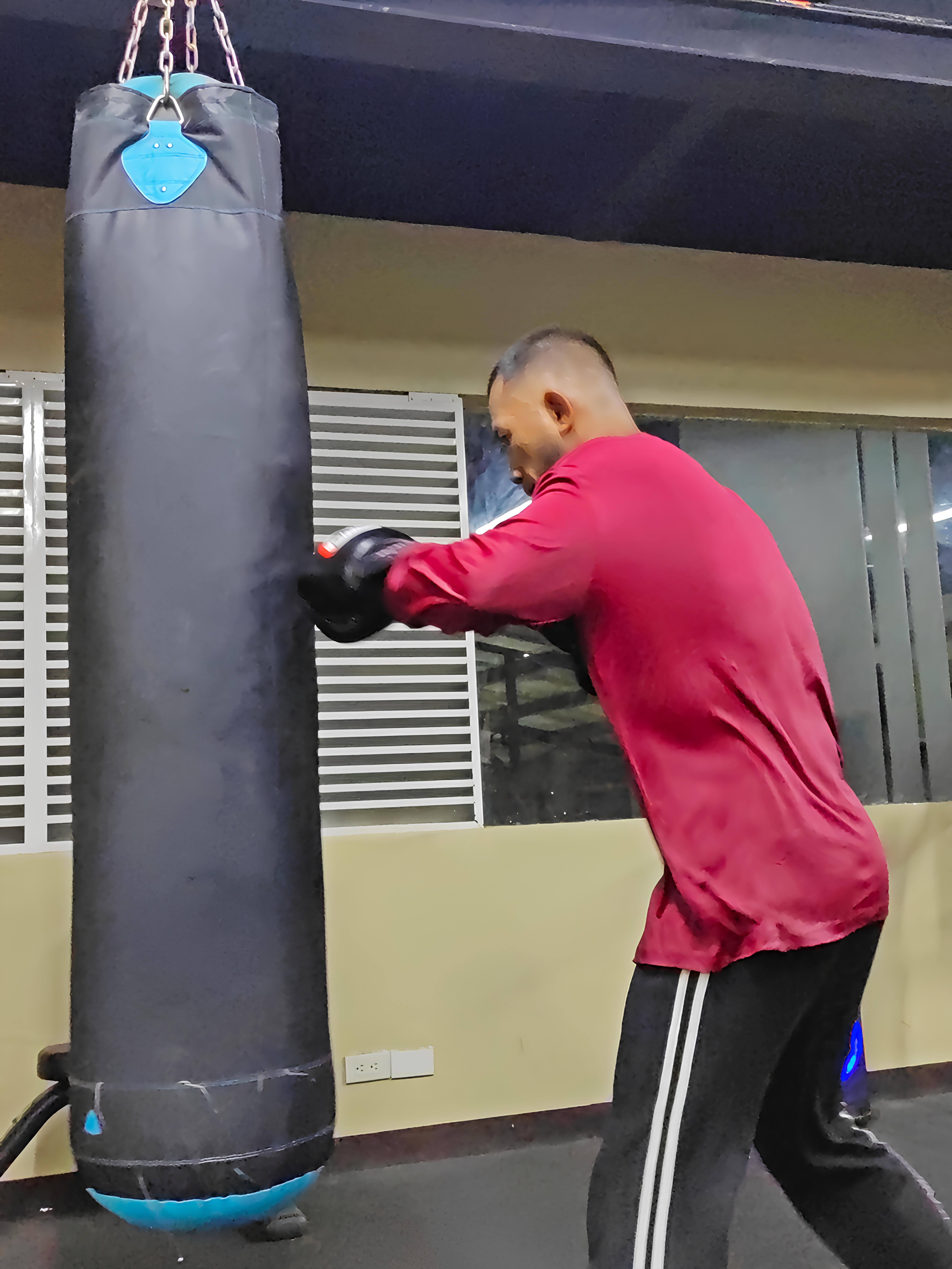 Member boxing with gloves in Niq's Fitness Gym, which offers martial arts near you